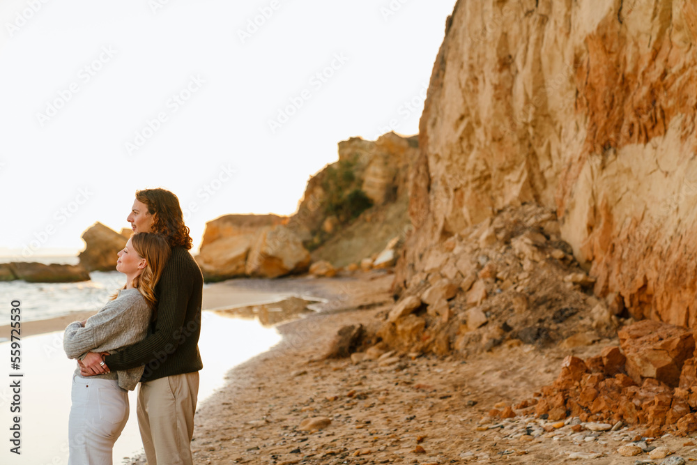Hugging couple enjoying sunset at beach