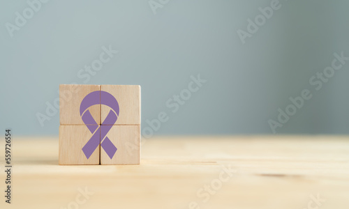 World Cancer Day (February 4) concept. Lavender ribbon (all cancer) icon on wooden cube blocks on minimal backround. Cancer awareness, national cancer survivor day. Healthcare and medical concept. photo