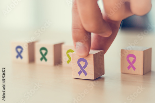 World cancer day (February 4). Colorful ribbons on wooden cube blocks background, cancer awareness, national cancer survivor day, world autism awareness day. Healthcare and medical concept.