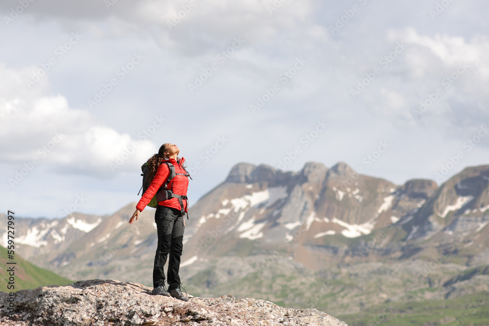 Hiker breathing fresh air in the top of a mountain