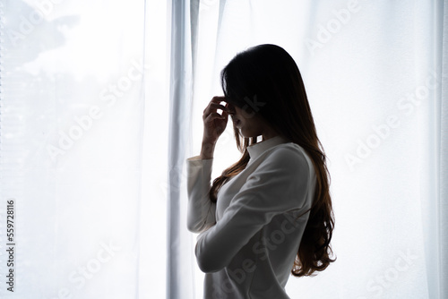 Photographie Stressed young Asian woman suffering on depression and standing alone in dark room at home