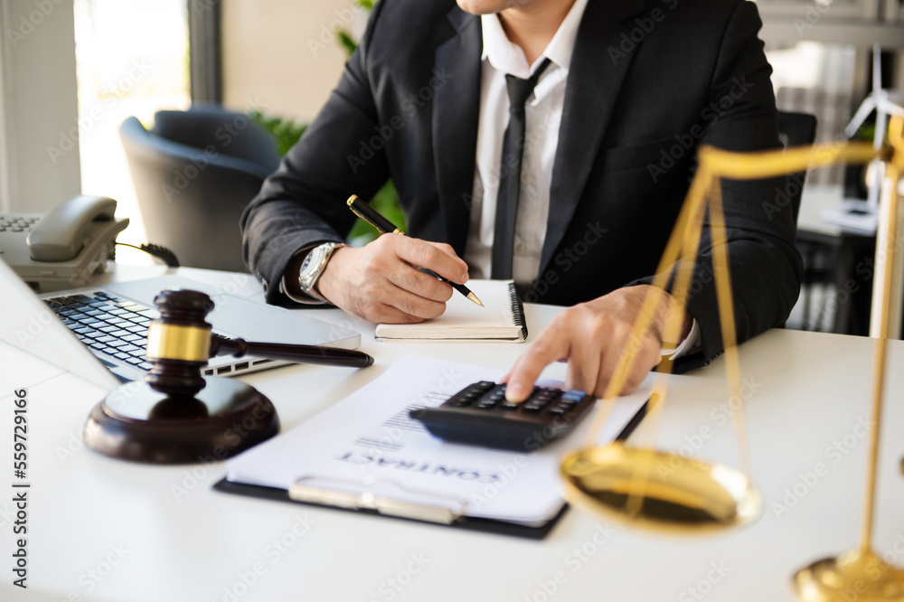 justice and law concept.businessman or lawyer or accountant working on accounts using a smart phone laptop digital tablet calculator and documents in dark office . justice and law concept.businessman or lawyer or accountant working on accounts using a smart phone laptop digital tablet calculator and documents in dark office .
