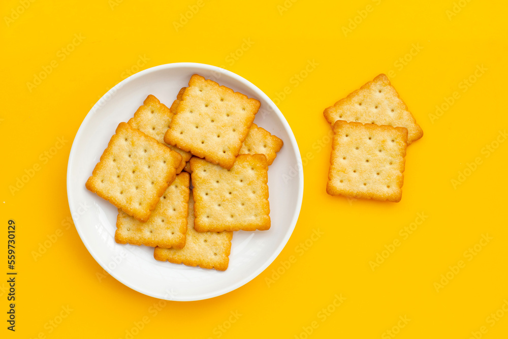 Dry cracker cookies on yellow background.