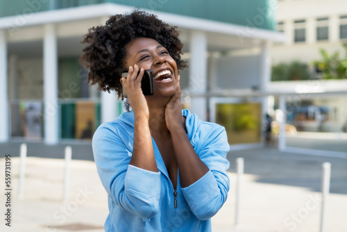Beautiful african american woman laughing and talking with boyfriend at phone