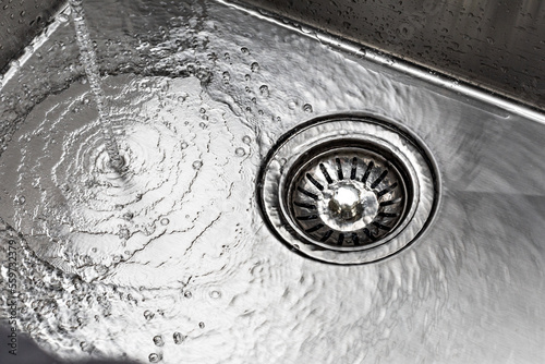 water drains down a stainless steel sink photo