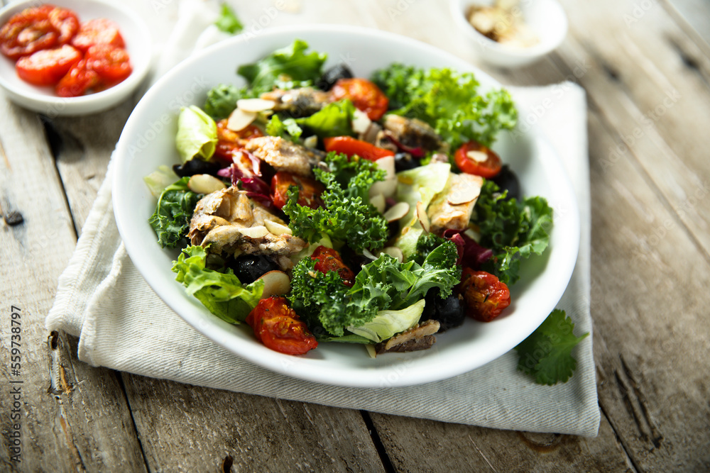 Healthy green salad with roasted tomatoes and fish