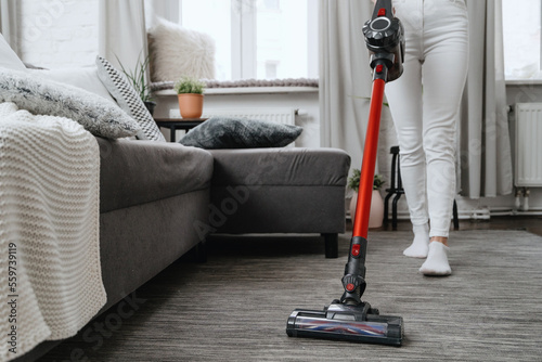 woman cleanup at home and vacuum rug on floor photo