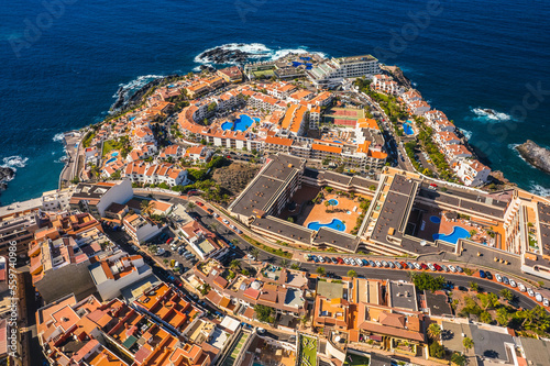 Aerial view of the city of Los Gigantes and the surrounding majestic cliffs. Sunny weather highlights the colors of the water.