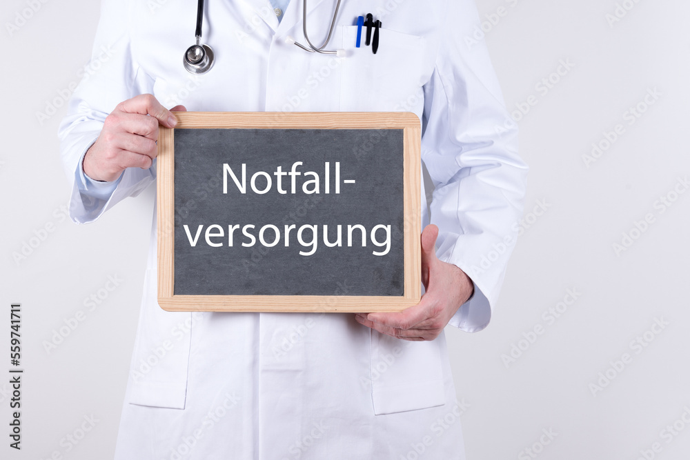 Arzt mit einer Tafel auf der Notfallversorgung steht