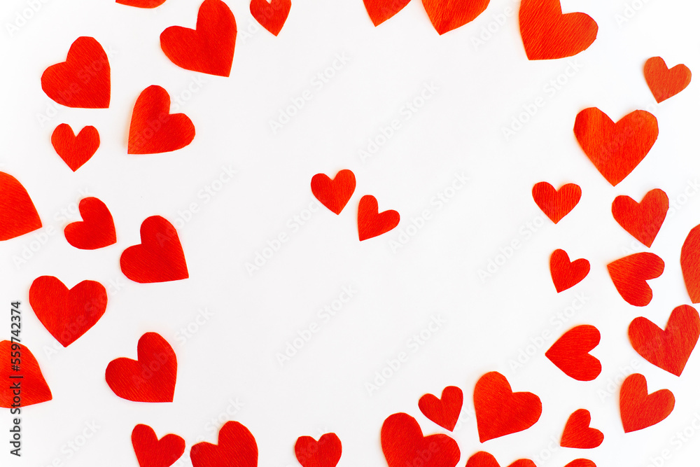 Valentine's Day background with red paper cut out hearts on white background. Top view. Holiday background.