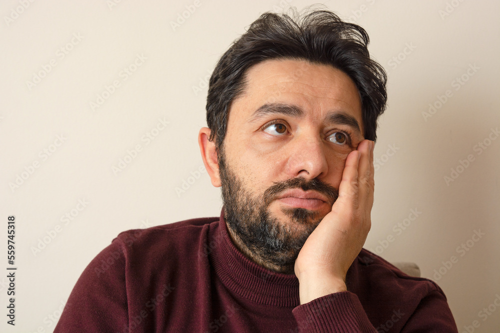 Thinking man, 35-40 years old. He is wearing a collared burgundy sweater.