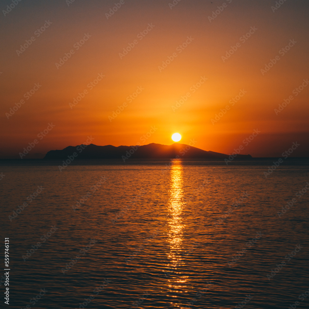 un coucher de soleil au dessus d'une ile