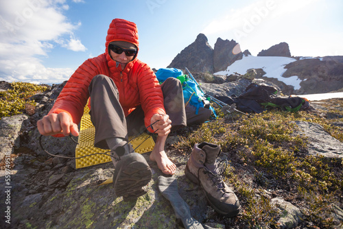 A climber laces up his boots in preparation to climb a neaby mountain. photo