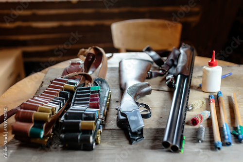 Close up of disassembled shotgun with ammunition and cleaning kit on table, Tikhvin, Saint Petersburg, Russia photo