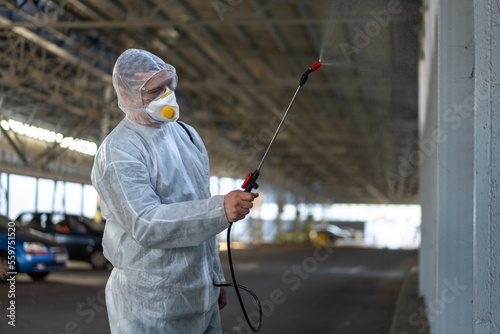 Worker wearing protective suit disinfection gear disinfect surface public place