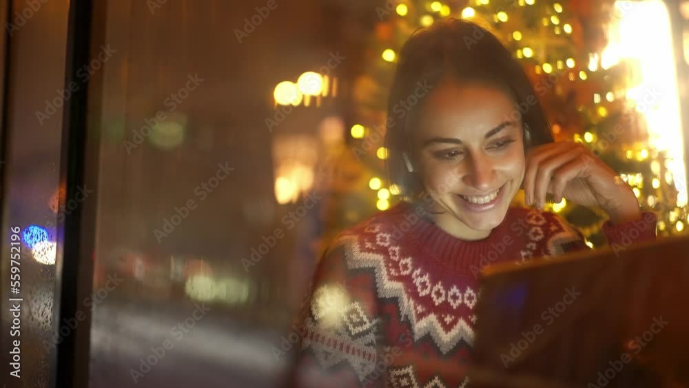 festive weared woman sits in decorated cafe close to window on Christmas Eve using laptop. girl dreamily looking at window. festive mood, making wishes, dreams concept festive weared woman sits in decorated cafe close to window on Christmas Eve using laptop. girl dreamily looking at window. festive mood, making wishes, dreams concept