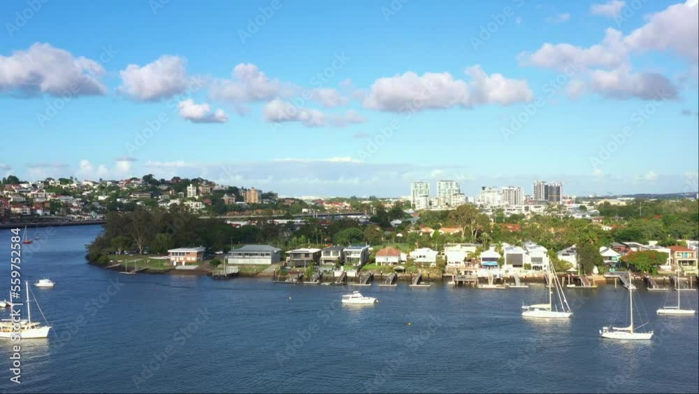 Aerial elevation shot capturing Brisbane river bend and riverfront Bulimba residential neighborhood, inner city suburb on a sunny day with beautiful blue sky, Queensland, Australia. Aerial elevation shot capturing Brisbane river bend and riverfront Bulimba residential neighborhood, inner city suburb on a sunny day with beautiful blue sky, Queensland, Australia.