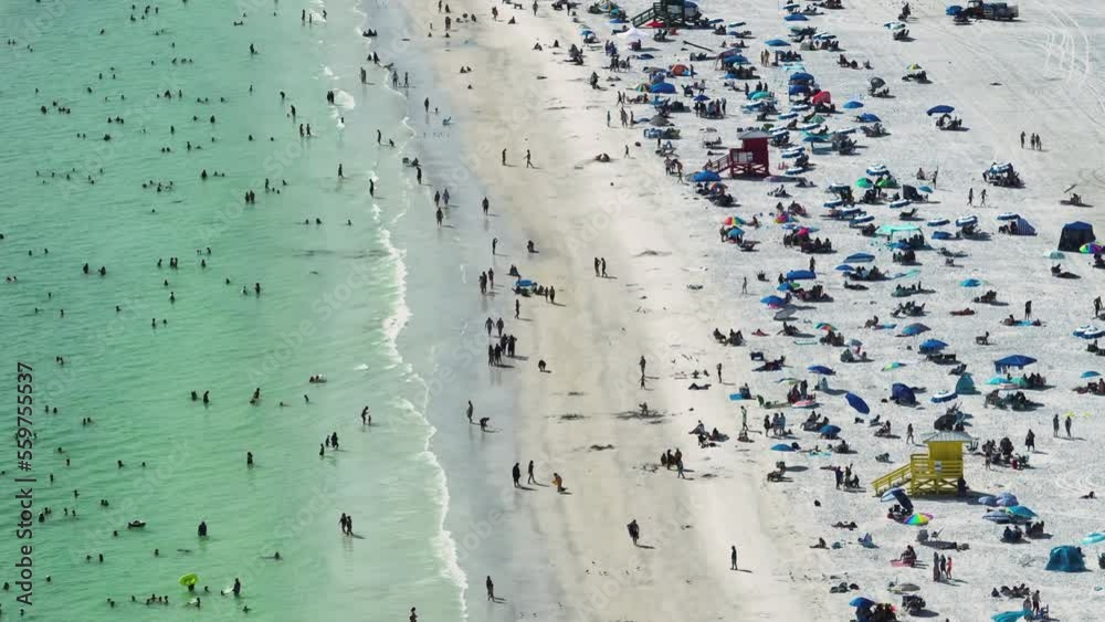 Aerial view of Siesta Key beach in Sarasota, USA. Many people enjoing vacation time swimming in gulf water and relaxing on warm Florida sun Aerial view of Siesta Key beach in Sarasota, USA. Many people enjoing vacation time swimming in gulf water and relaxing on warm Florida sun