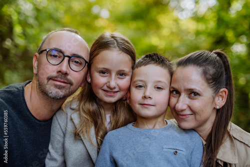 Portrait of happy family with kids in a forest. © Halfpoint