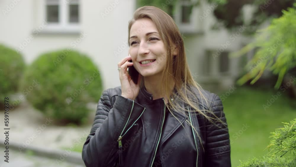 Early thirties woman in the garden is talking and laughing during her phone call. Early thirties woman in the garden is talking and laughing during her phone call.