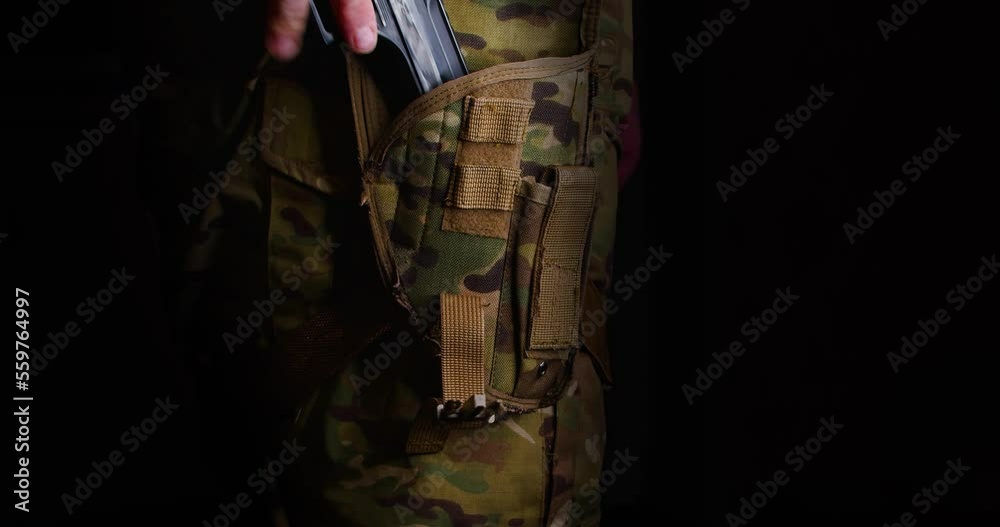 4k video military man pulls a pistol from a holster in the dark and removes the safety. 4k video military man pulls a pistol from a holster in the dark and removes the safety.