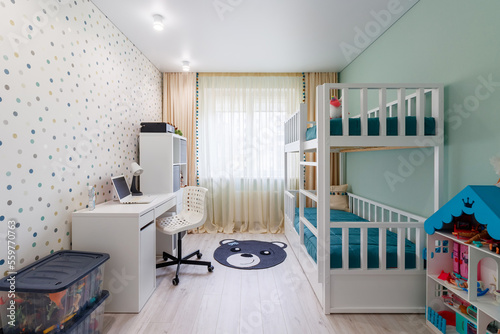 A new modern children's room with a bunk bed with a workplace and wallpaper in multi -colored peas. New house. Inner photo photo