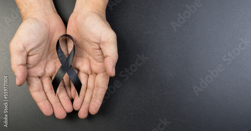 Hand hold black ribbon on background.
Bereavement and Mourning is the grieving process concept.