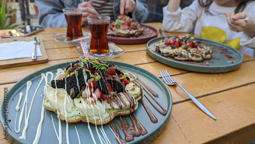 Delicious waffle dessert with fruits on the table of a street restaurant