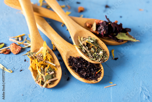 Different Kind of Tea in Wooden Spoons Black Green Herbal Dried Tea Blue Background Horizontal
