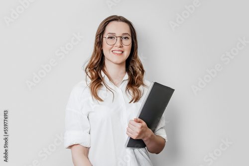 Woman psychologist in a white shirt with glasses on a white background in the studio
