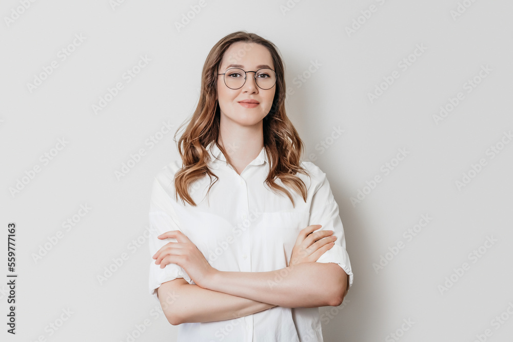 Fototapeta premium Woman psychologist in a white shirt with glasses on a white background in the studio