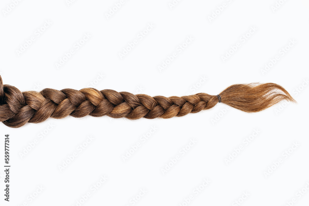 Female hair in the form of a braid on a white isolated background. Red hair braided close-up. Beautiful healthy natural female hair without dyeing - obrazy, fototapety, plakaty 