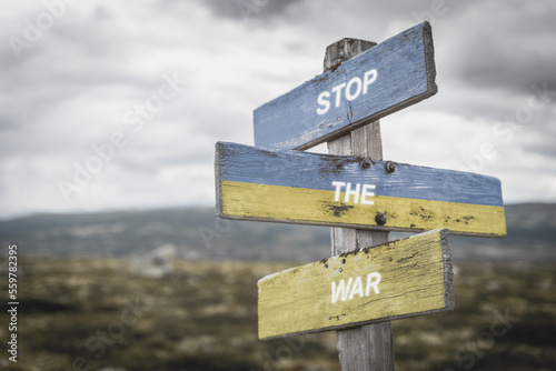 stop the war text on wooden signpost with the ukranian flag painted on it. Peace and war concept.
