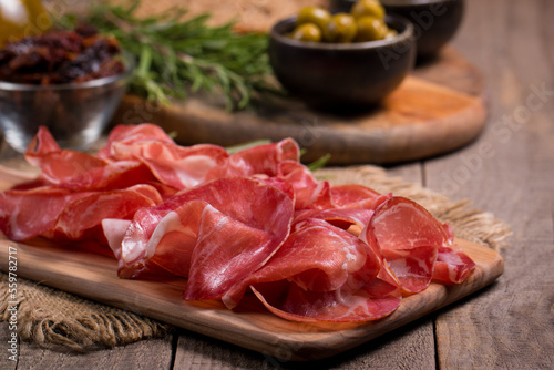 Italian slices of coppa, capocollo, capicollo, bresaola or cured ham with rosemary. Raw food.  