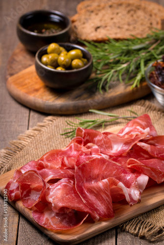 Italian slices of coppa, capocollo, capicollo, bresaola or cured ham with rosemary. Raw food. 