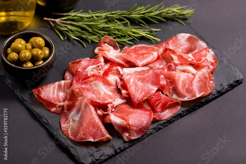 Italian slices of coppa, capocollo, capicollo, bresaola or cured ham with rosemary. Raw food.   photo