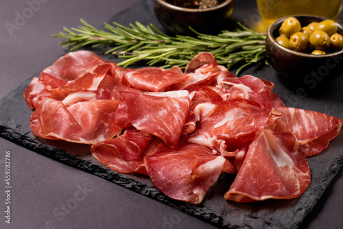 Italian slices of coppa, capocollo, capicollo, bresaola or cured ham with rosemary. Raw food.   photo