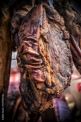 An outdoor stall with pieces of bacon and dried meat being sold photo