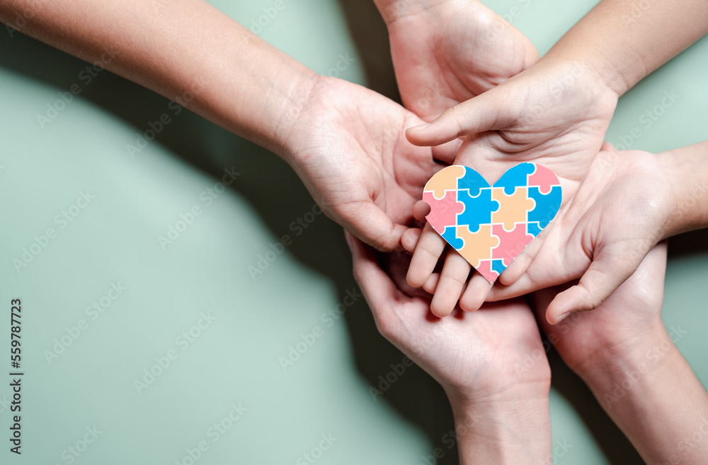 Father, Mother, Children holding heart jigsaw puzzle, Color puzzle symbol of awareness for autism spectrum disorder family support. Autism World Awareness Day. Father, Mother, Children holding heart jigsaw puzzle, Color puzzle symbol of awareness for autism spectrum disorder family support. Autism World Awareness Day.