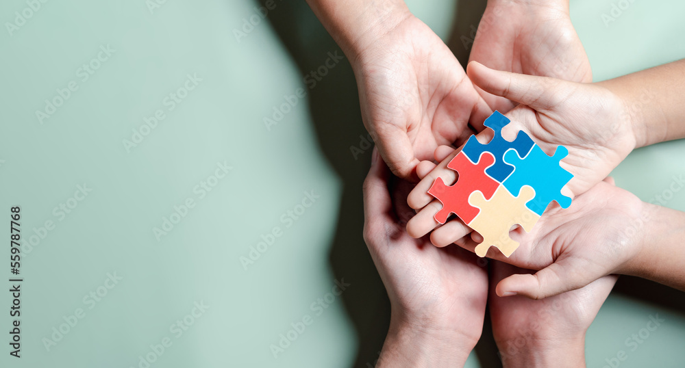 Color puzzle symbol of awareness for autism spectrum disorder family support. Father, Mother, Children holding jigsaw puzzle Autism World Awareness Day.