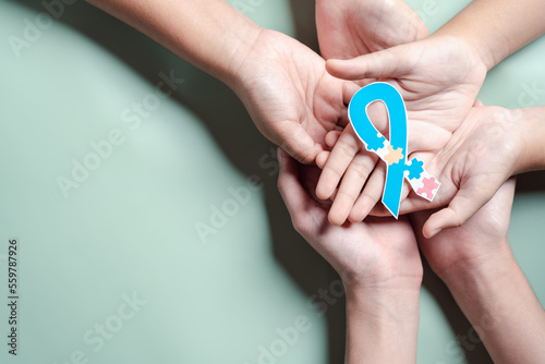 Father, Mother, Children holding ribbon jigsaw puzzle, Color puzzle symbol of awareness for autism spectrum disorder family support. Autism World Awareness Day.