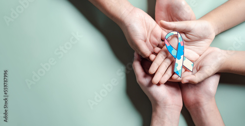 Father, Mother, Children holding ribbon jigsaw puzzle, Color puzzle symbol of awareness for autism spectrum disorder family support. Autism World Awareness Day.