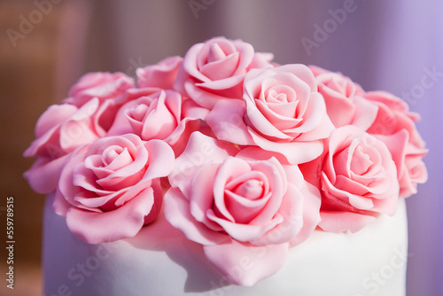 pink roses from mastic close-up - decoration on the wedding cake