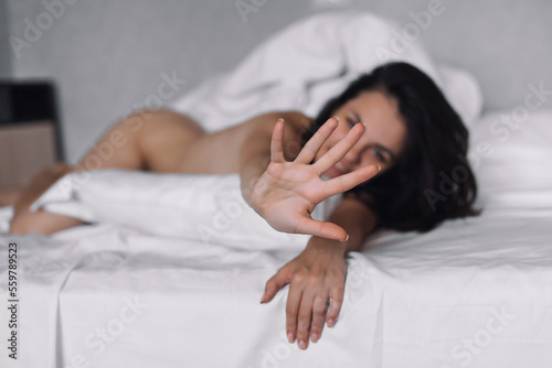 sexy happy nude brunette girl lying in bed in the bedroom