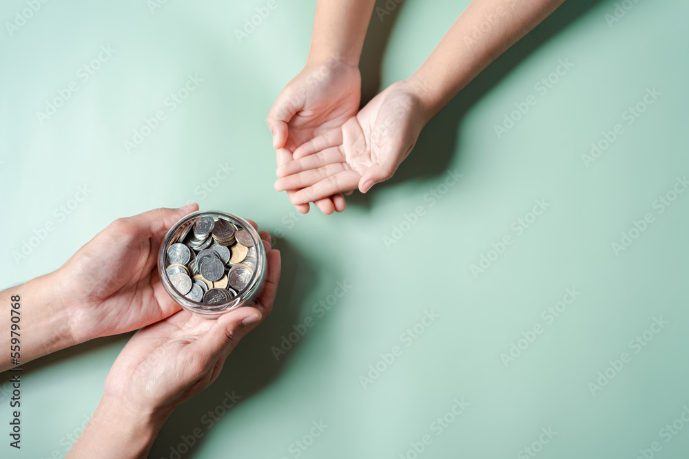 hands of adult and child holding money jar, donation, saving, fundraising charity, family finance plan, inflation, superannuation, investment, retirement concept hands of adult and child holding money jar, donation, saving, fundraising charity, family finance plan, inflation, superannuation, investment, retirement concept
