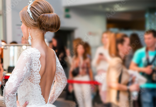 Competition among wedding stylists. A model in a wedding dress, with hair and make-up shows the result of the stylist's work. photo