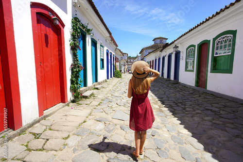 Holidays in Paraty, Brazil. Back view of beautiful fashion girl enjoying visiting historic town of Paraty, Rio de janeiro. Summer vacation in Brazil. photo
