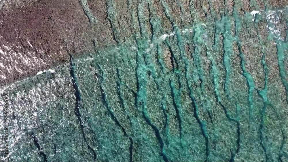 Océan indien filmé par drone sur l'île de la Réunion. Coraux et eau bleu turquoise transparente avec vague et houle sur le sable de la plage. Océan indien filmé par drone sur l'île de la Réunion. Coraux et eau bleu turquoise transparente avec vague et houle sur le sable de la plage.