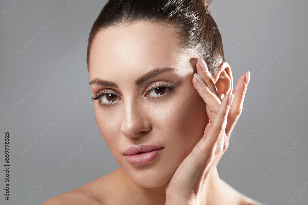 Portrait of woman with beauty face and perfect skin on gray background. Skin care. Cosmetology, beauty and spa.