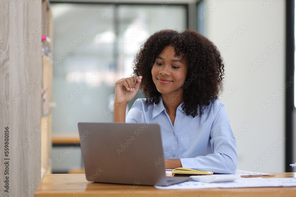 Portrait of attractive african american businesswoman working with laptop and documents on office desk. Portrait of attractive african american businesswoman working with laptop and documents on office desk.